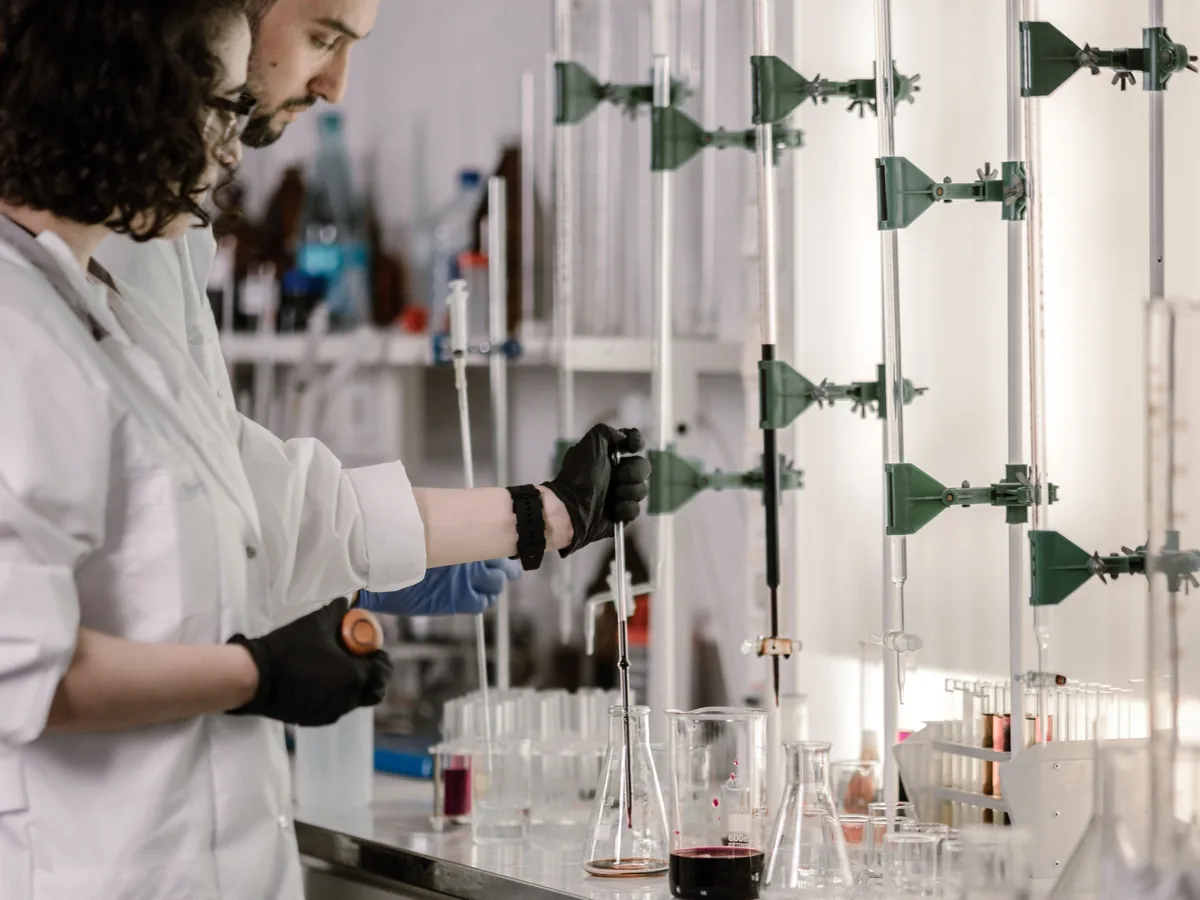 Scientists in lab coats work with test tubes in a modern laboratory.