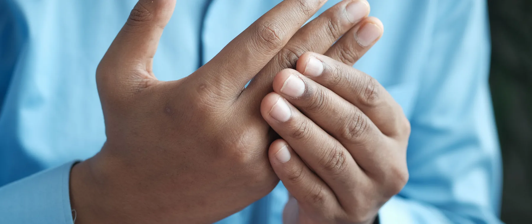 A man holding one hand in the other, as people do with nerve pain