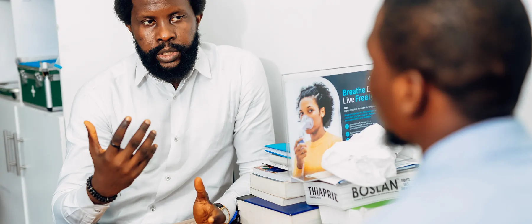 A doctor discusses health concerns with a patient at a medical office in Lagos, Nigeria.
