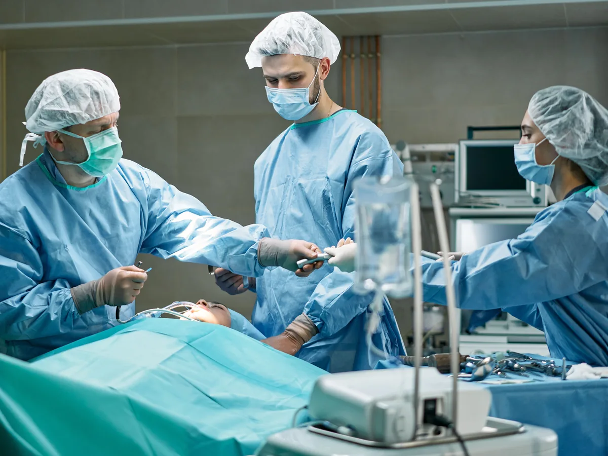 Medical team performing surgery in well-equipped operating room with focus.