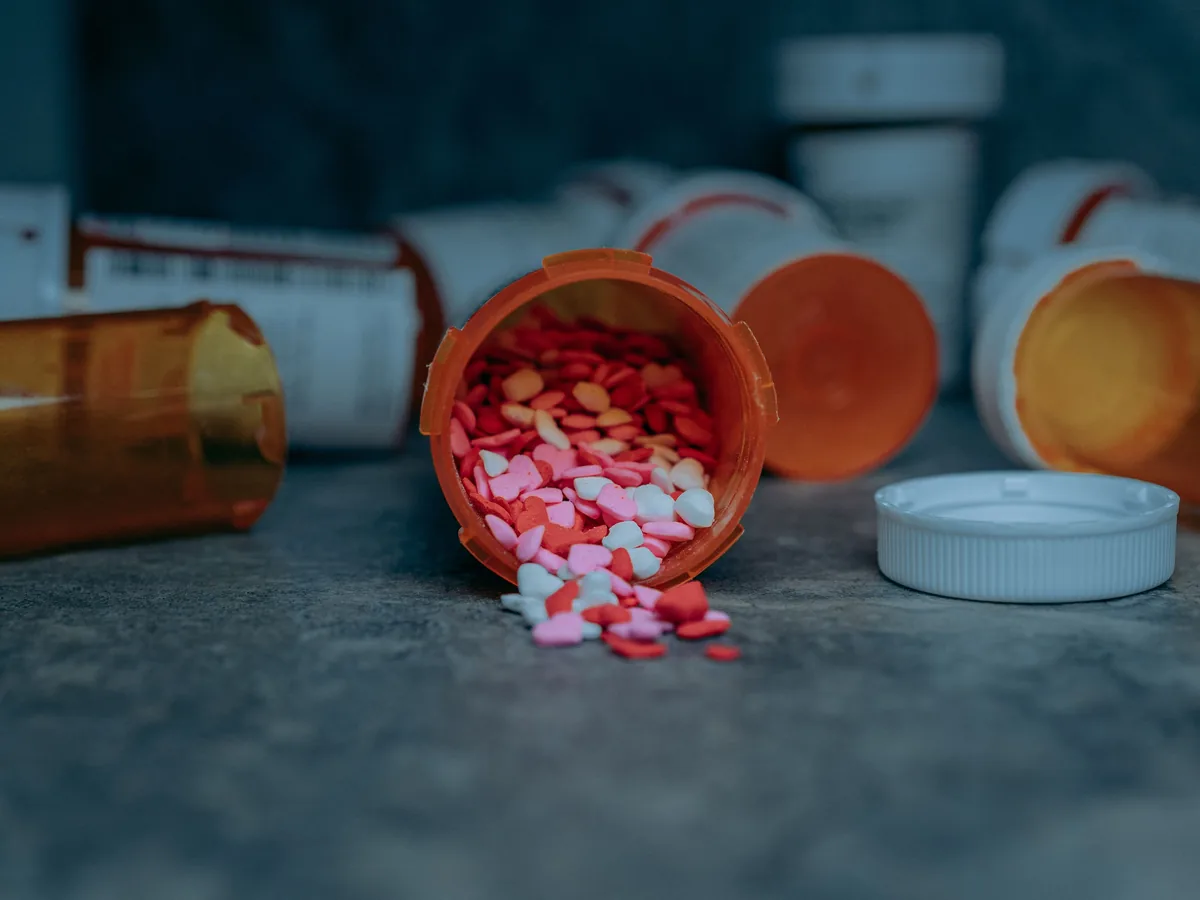 Colorful pills spilling from a prescription bottle on a counter in Portland, OR.