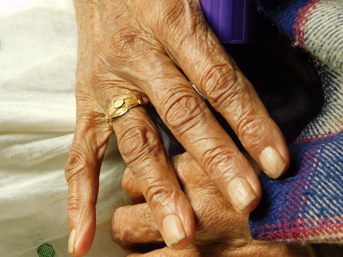 Detailed view of elderly hands with a gold ring, symbolizing wisdom and experience.
