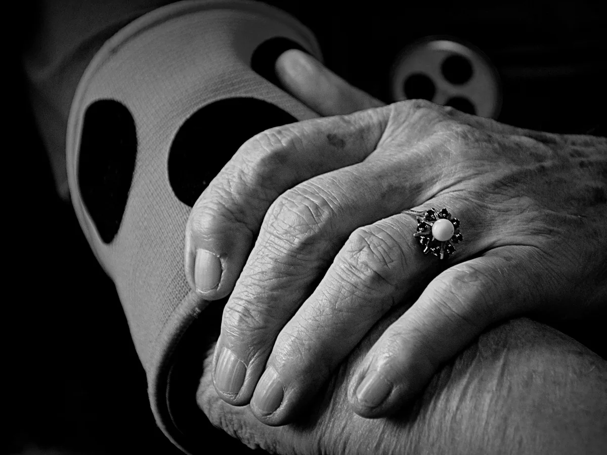 A close-up grayscale photograph capturing the detail and texture of elderly hands with a decorative ring, conveying timeless elegance.