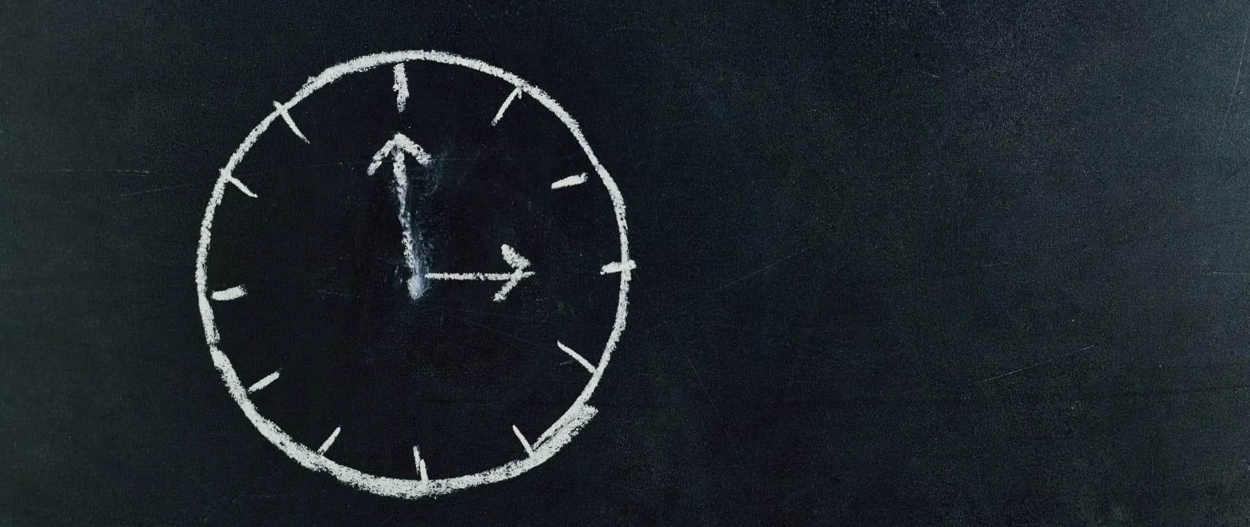 Chalk-drawn clock on a blackboard, symbolizing time and education concepts.