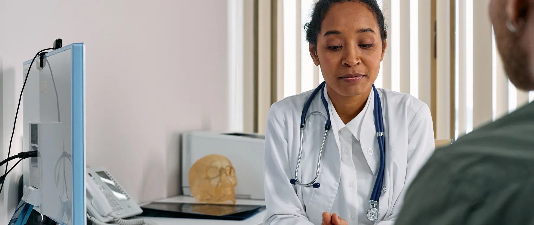 A physician talking a patient through treatment options at a desk