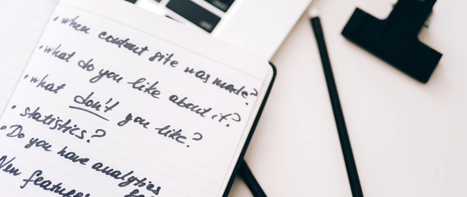 A close-up view of a notebook with handwritten notes alongside a laptop for planning and strategy.
