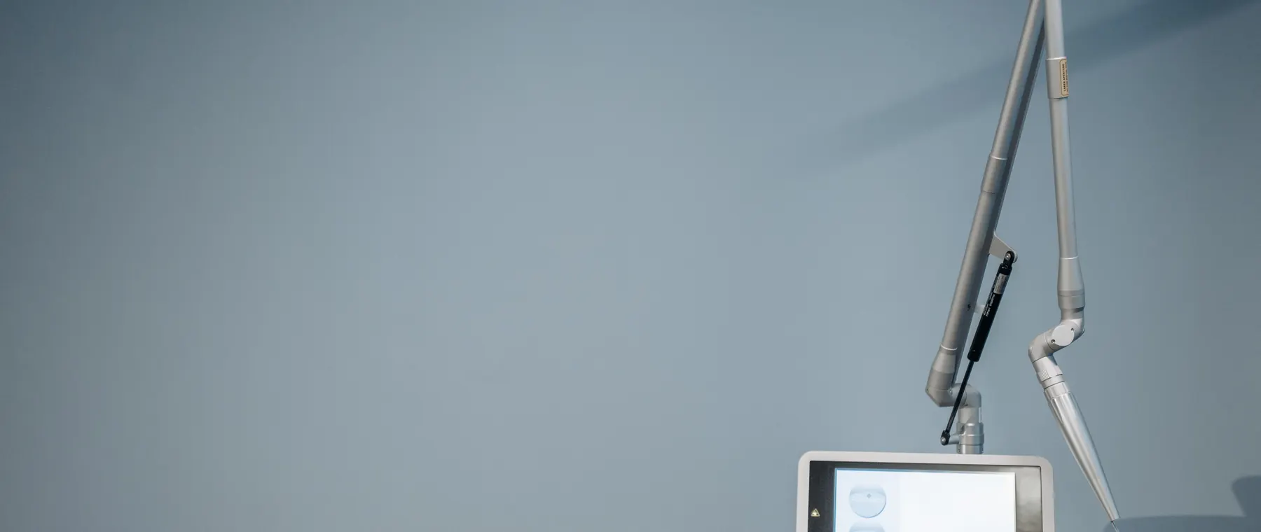 A high-tech medical device with a tablet screen in a clinical environment.